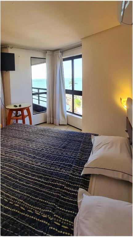a bedroom with a bed with a view of the ocean at Flat no Iate Plaza Hotel in Fortaleza