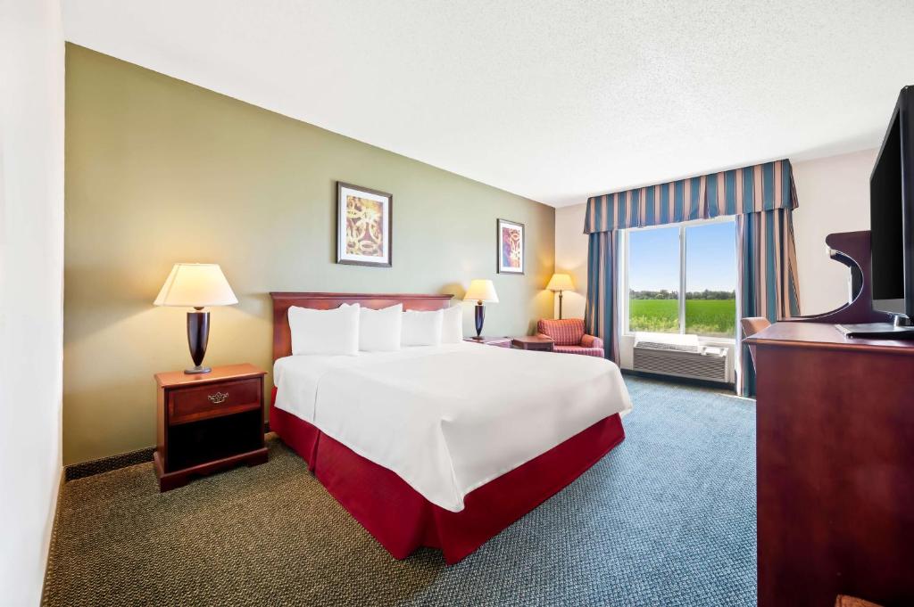 ein Hotelzimmer mit einem großen Bett und einem Fenster in der Unterkunft Best Western Annawan Inn in Annawan