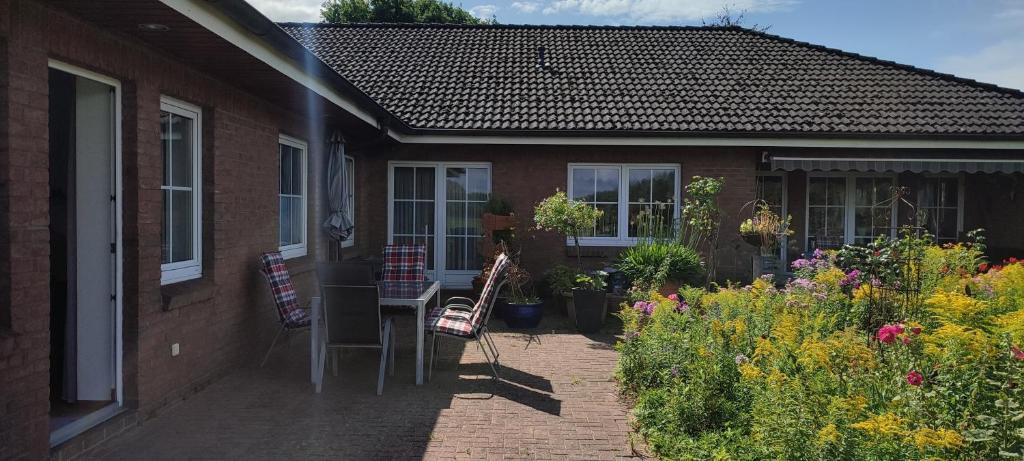 a house with a patio with chairs and flowers at Ferienwohnung Ehmsen in Groß Vollstedt
