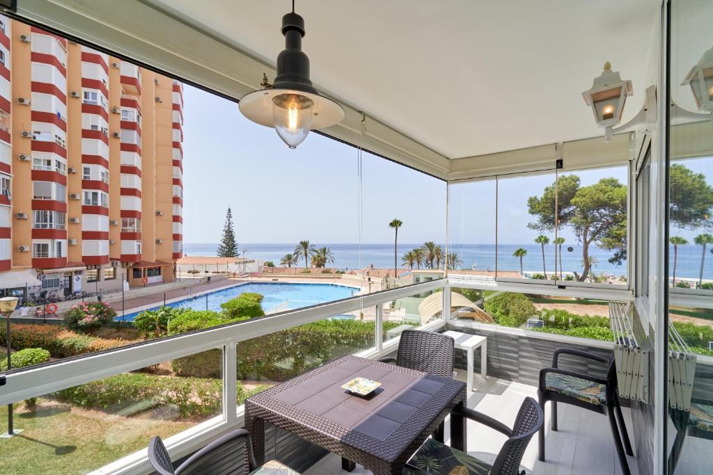 a balcony with a table and chairs and a view of the ocean at Primera línea con terraza A104 in Torrox