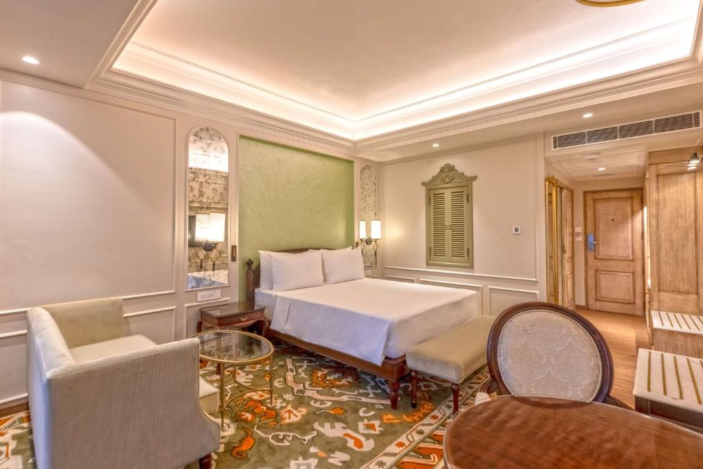 a bedroom with a bed and a table and chairs at Namah Nainital, a member of Radisson Individuals Retreats in Nainital