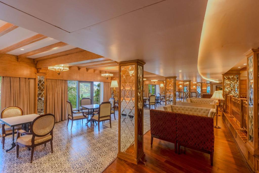 a dining room with tables and chairs and a bar at Namah Nainital, a member of Radisson Individuals Retreats in Nainital