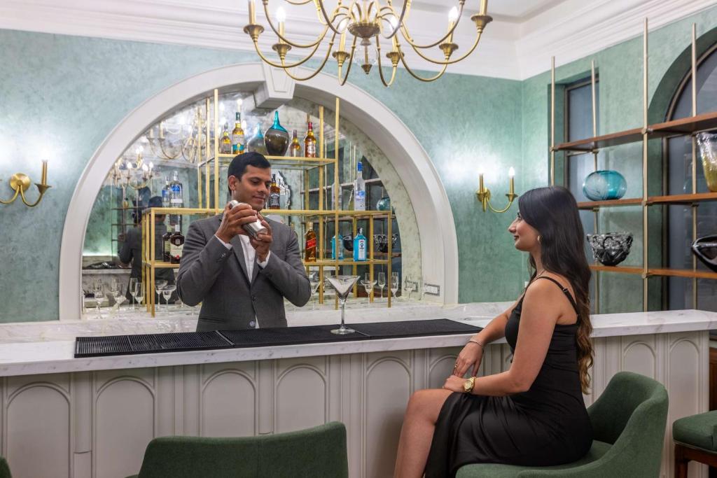 a man and a woman sitting at a bar in front of a mirror at Namah Nainital, a member of Radisson Individuals Retreats in Nainital