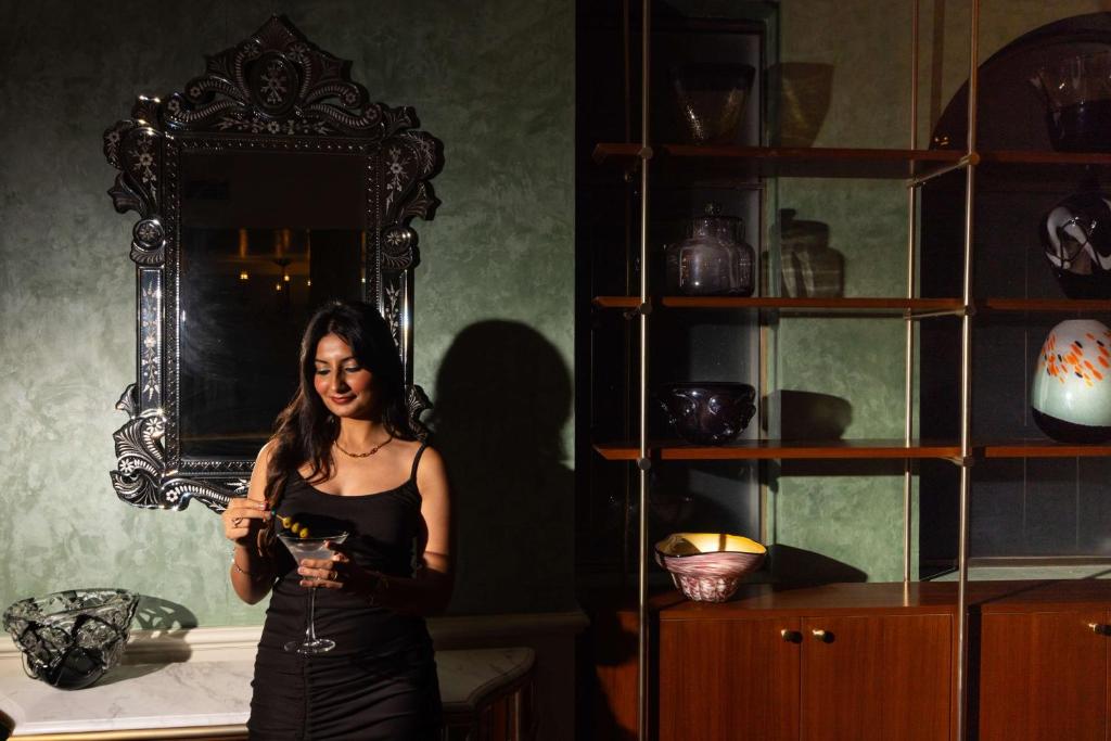 a woman is standing in front of a mirror at Namah Nainital, a member of Radisson Individuals Retreats in Nainital