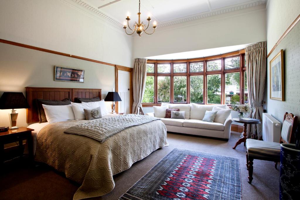 Olivers Central Otago في كلايد: غرفة نوم بسرير كبير وأريكة