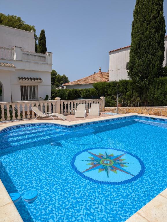 a large blue swimming pool with chairs around it at Chalet independiente con piscina in Partida de La Cañada
