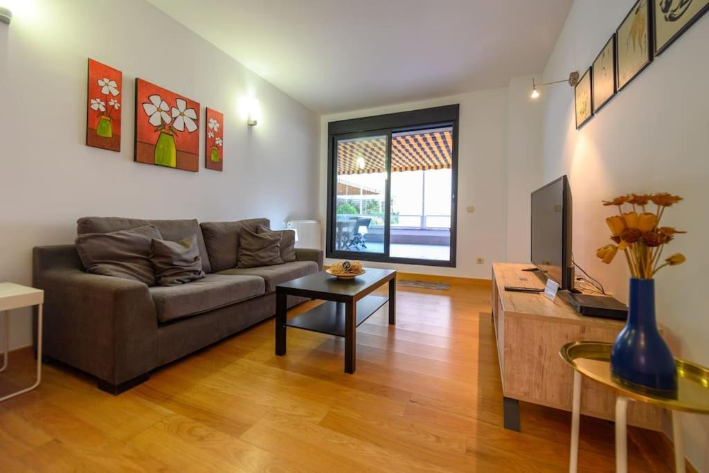 ein Wohnzimmer mit Couch und Tisch in der Unterkunft Moderno Apartamento TEMPORAL Familiar con Terraza SOD1 in Madrid