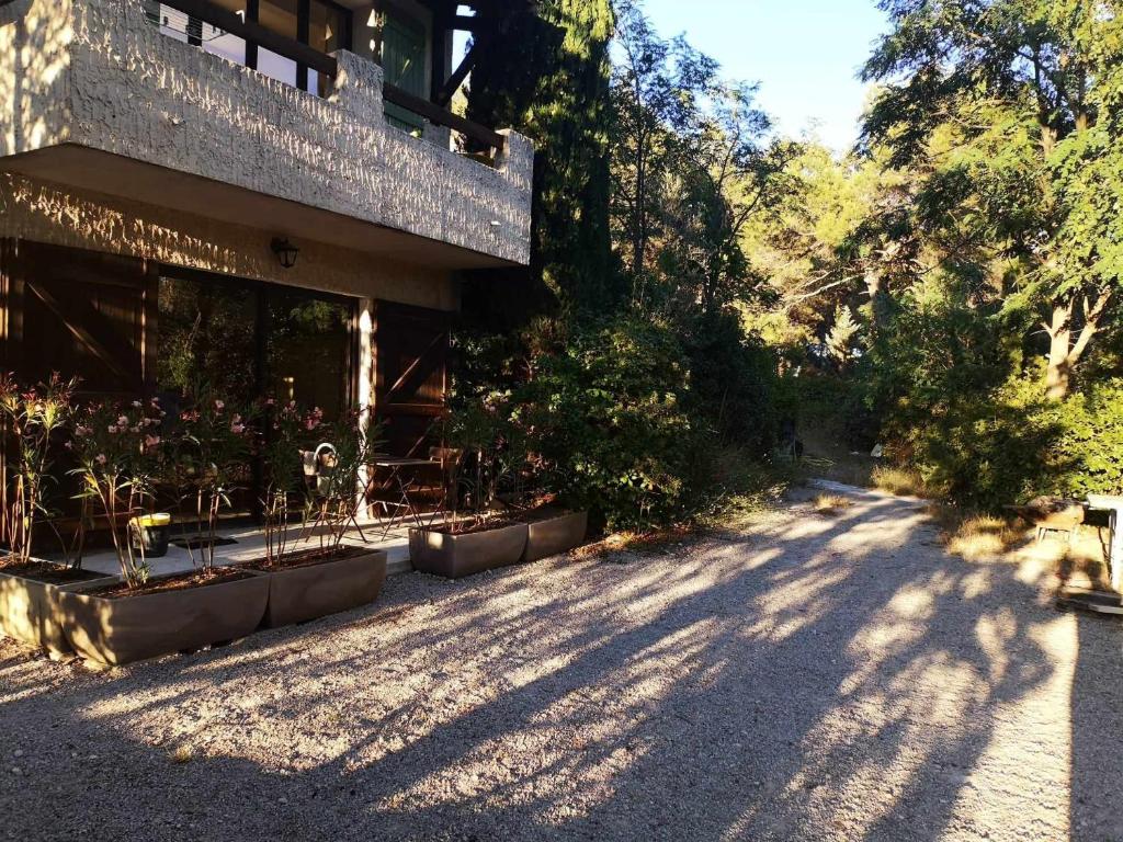 un bâtiment avec quelques plantes sur le côté d'une route dans l'établissement Studio en Provence, à Mimet