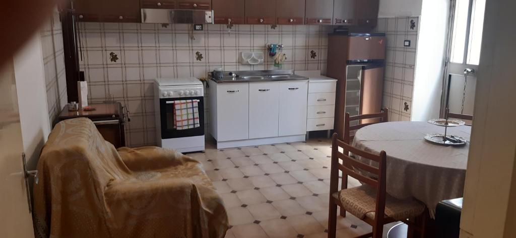 a kitchen with a table and a stove and a table and chairs at La casa dei Giomi in Deiva Marina