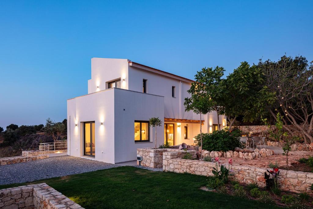 a white house with a stone wall at Villa Sun, Roussospiti in Roussospítion