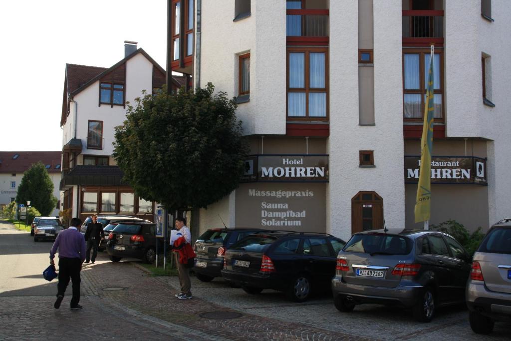 un groupe de voitures garées devant un bâtiment dans l'établissement Hotel Mohren, à Ochsenhausen