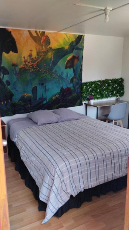 a bedroom with a bed and a painting on the wall at El valle in Copiapó