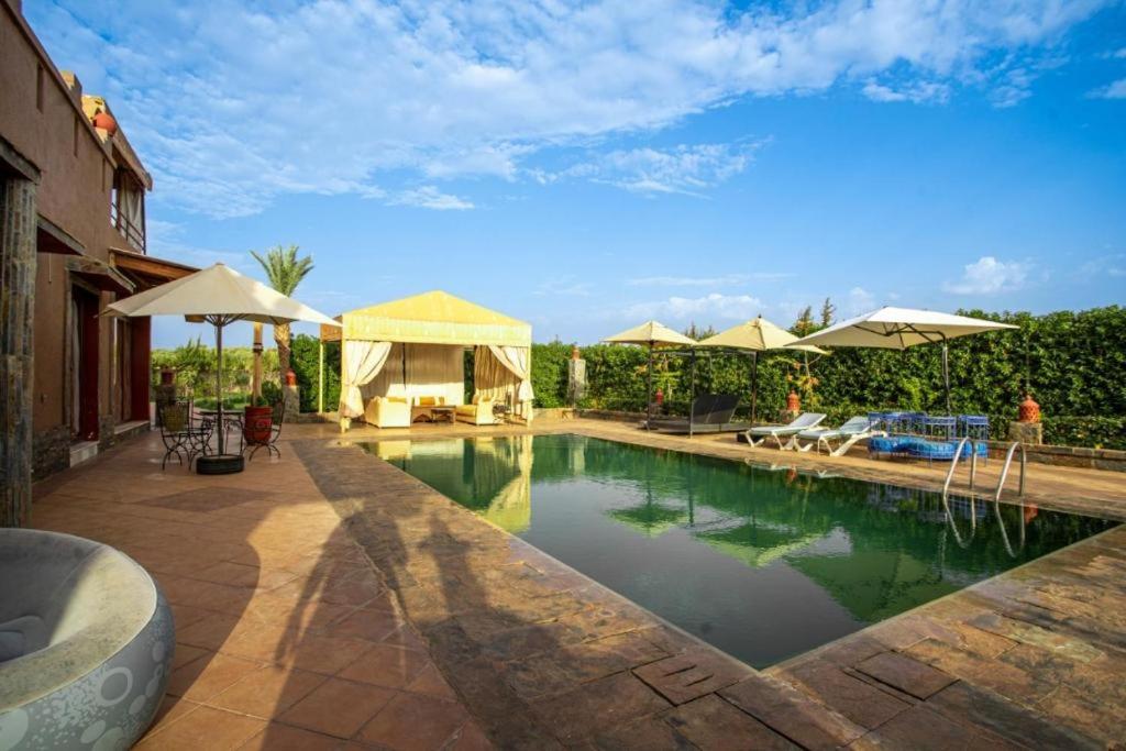 einen Pool mit Sonnenschirmen und einen Pool in der Unterkunft Villa Kenza Marrakech in Tillouna