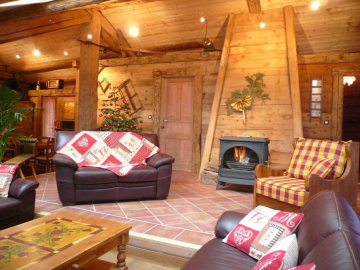 Elle comprend un salon doté d'un mobilier en cuir et d'une cheminée. dans l'établissement Chalet Au Bon Vieux Temps, au Grand-Bornand