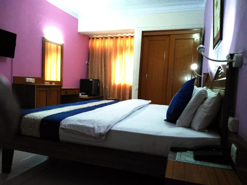 a bedroom with a large bed with purple walls at Hotel The Citadel in Vasco Da Gama