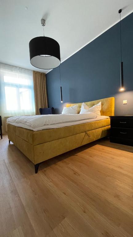 a large bed in a bedroom with a blue wall at NEU! OASIS - FeWo am Harz, hochwertig Kernsaniert, 83 qm, EG in Nordhausen