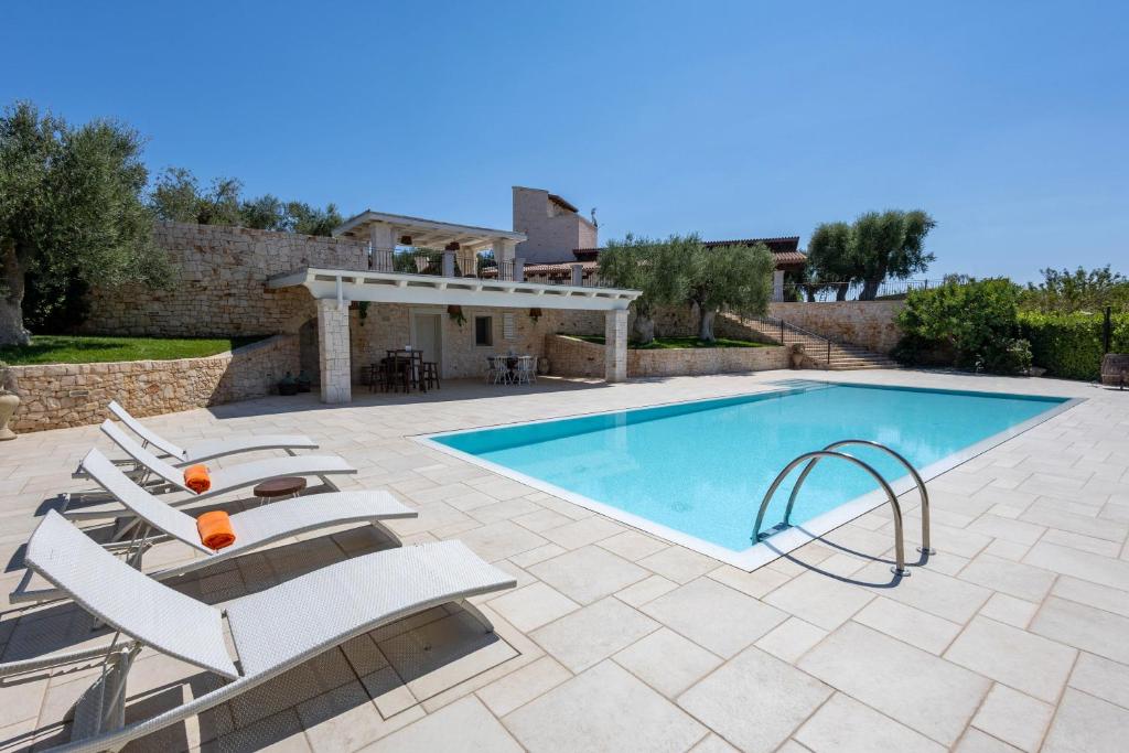 een zwembad met ligstoelen en een villa bij WePuglia - Torre Nuova Luxury in Castellana Grotte
