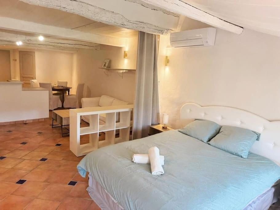 une chambre avec un grand lit et une cuisine dans l'établissement Angelina, cœur du village, calme, proches restaurants et supermarché, à Bargemon