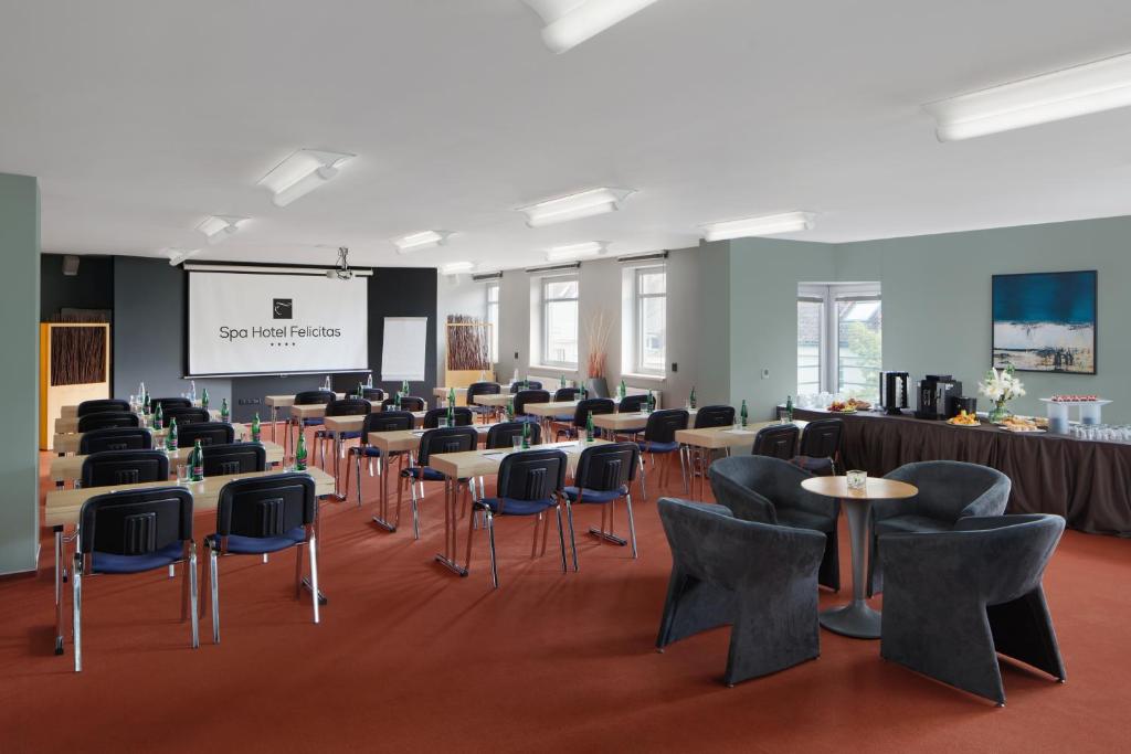 a large room with tables and chairs and a projection screen at Spa Hotel Felicitas in Poděbrady
