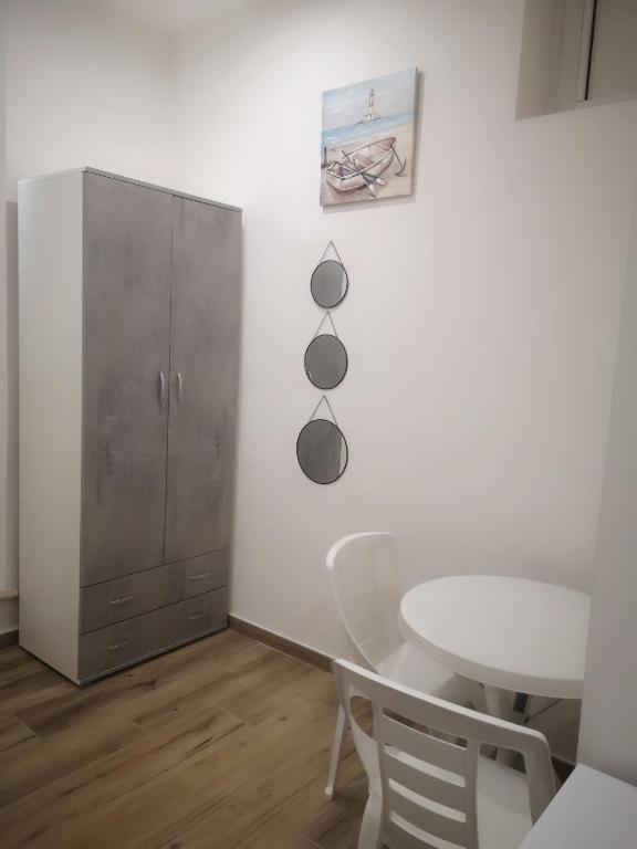 a white dining room with a table and a cabinet at Terracina Holiday Succursale in Terracina