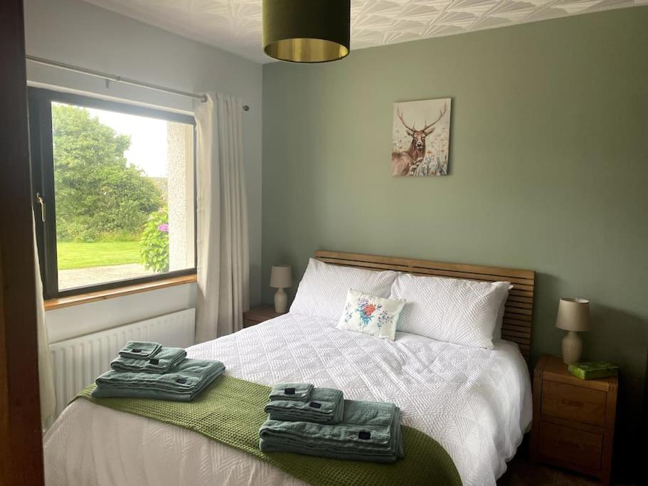 a bedroom with a bed with two towels on it at Eileen's Cottage in Castlerock