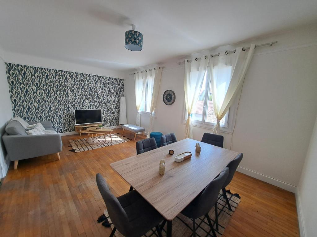 un salon avec une table et des chaises en bois dans l'établissement Maison de ville avec cour et terrasse, à Vichy