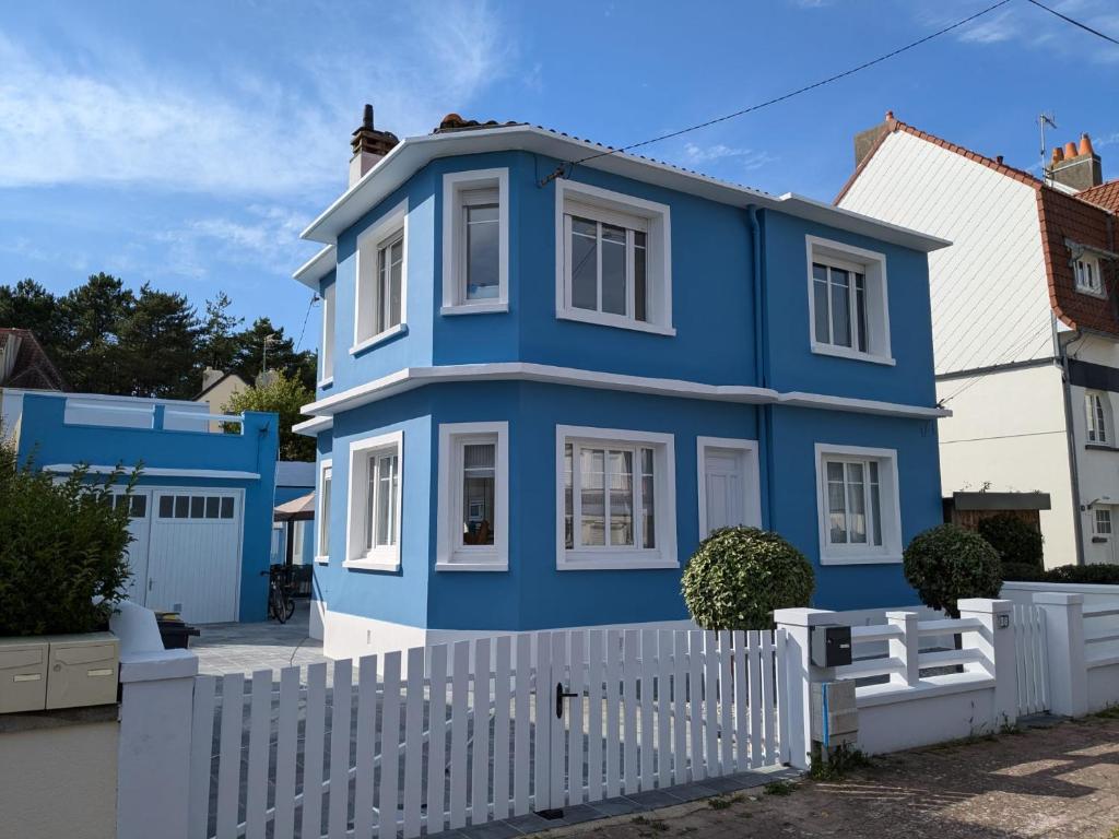 een blauw huis met een wit hek bij Villa Gisèle in Le Touquet-Paris-Plage