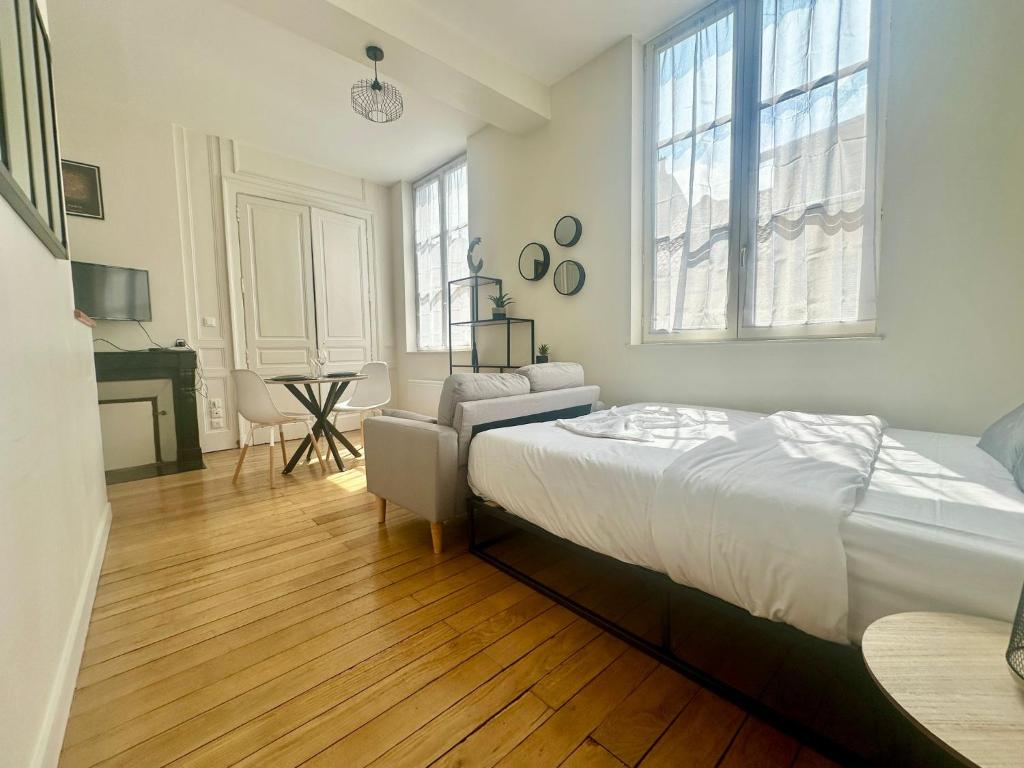 une chambre avec un lit, une chaise et un bureau dans l'établissement Le Thémis, cosy et élégant, à Limoges