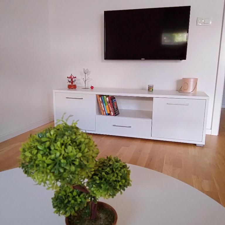 a white entertainment center with a flat screen tv on a wall at Apartman Anny in Široki Brijeg