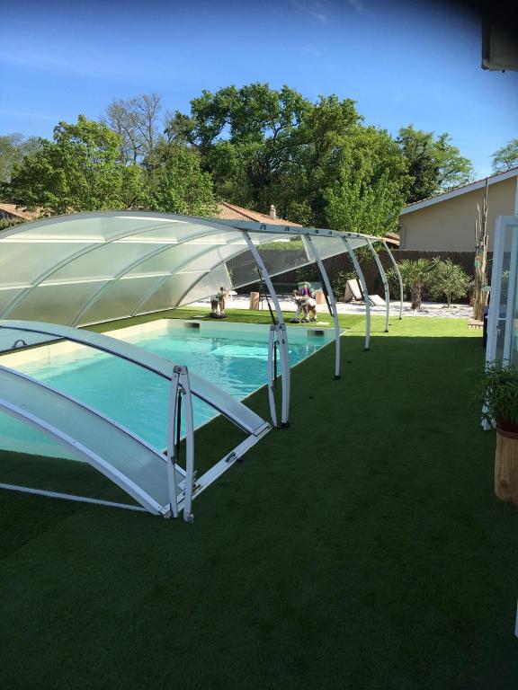 - un auvent au-dessus d'une piscine dans une cour dans l'établissement Les Tamaris d'Audenge, à Audenge