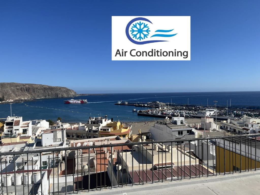 a view of a harbor with a sign for art conditioning at Edificio Gloria in Los Cristianos