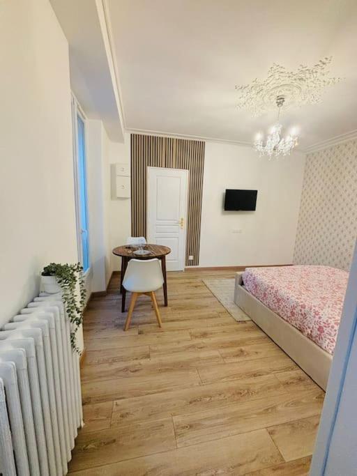 une chambre avec un lit et une table avec une chaise dans l'établissement Le Royal, proche Paris & Disney, à Noisy-le-Grand