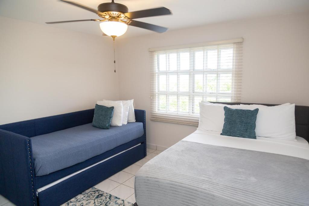 a bedroom with a blue couch and a window at The View, Goodwood Park Lux Townhouse in Diego Martin