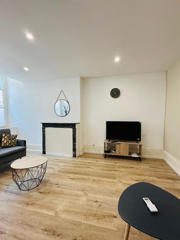 un salon avec un canapé et une télévision dans l'établissement Le Petit Bourbonnais, à Moulins