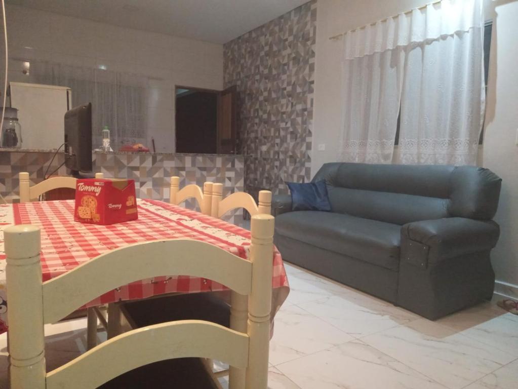 Una sala de estar con un sofá azul y una mesa. en Casa recém construída na Ilha Comprida, en Ilha Comprida