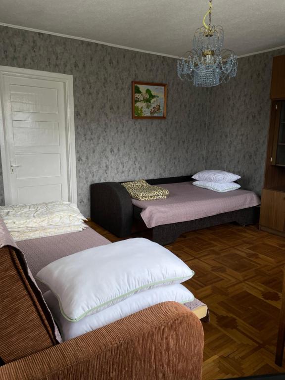 een kamer met 2 bedden en een kroonluchter bij Pas Ireną Šventojoje in Palanga
