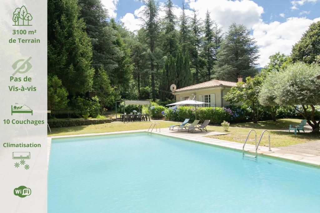 a large swimming pool in a yard with a house at Magnifique Maison Paisible avec Piscine in Jaujac