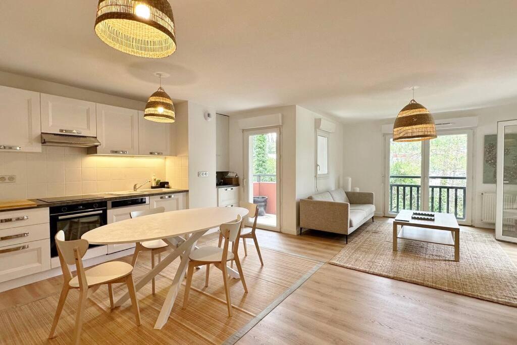 une cuisine et un salon avec une table et des chaises dans l'établissement Spacieux et confortable appartement T3 de 73 m2, à Soorts-Hossegor