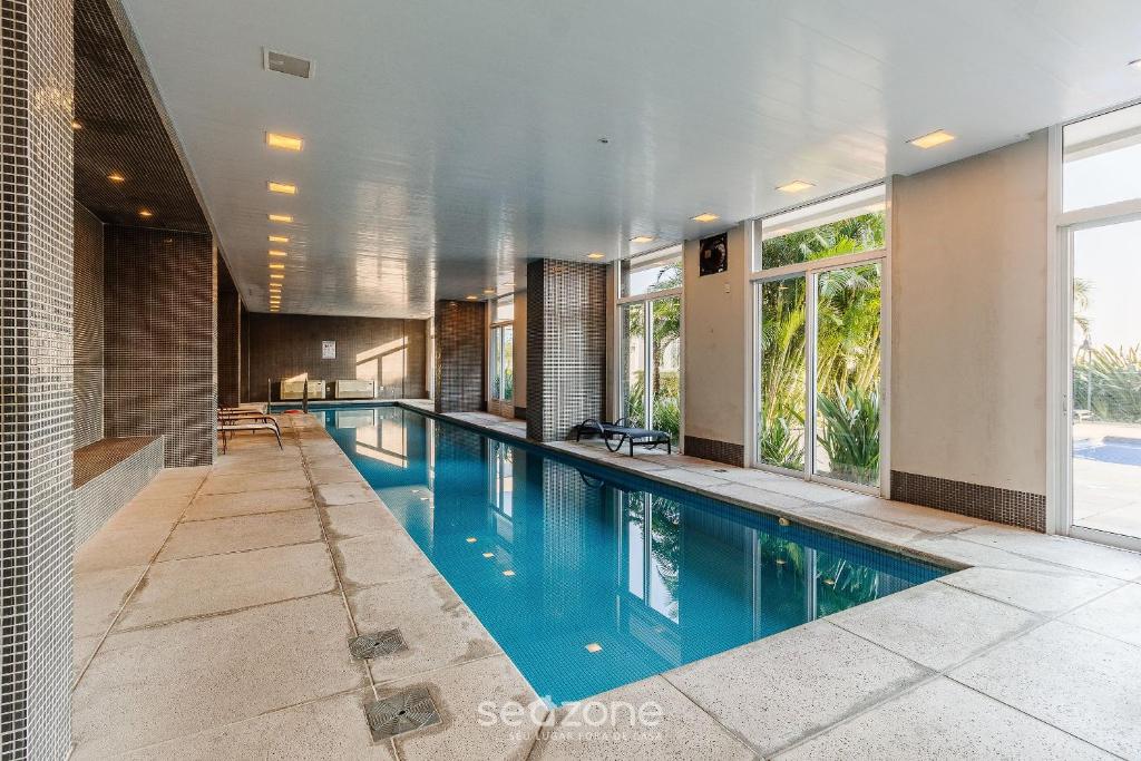 Una gran piscina con agua azul en un edificio. en Loft de Luxo c/bela Vista no Petrópolis AHO1402, en Porto Alegre