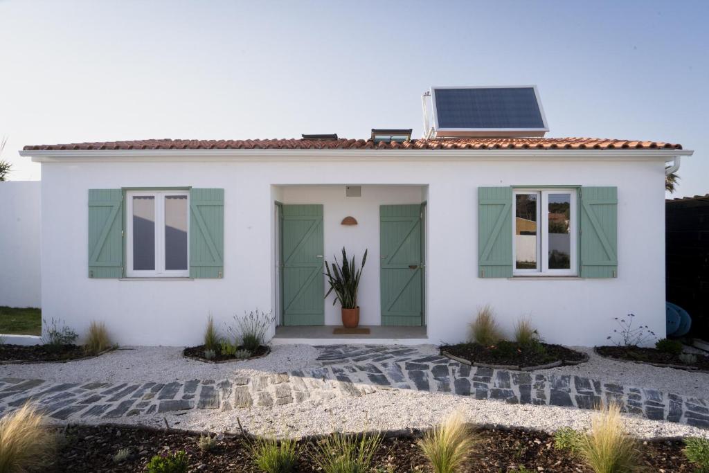 una casa bianca con pannelli solari sul tetto di B&B Casa Areia a Colares