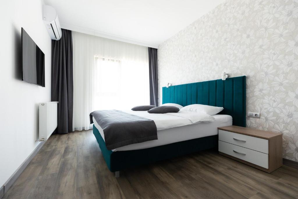 a bedroom with a large bed with a blue headboard at Aquangar in Cehu Silvaniei