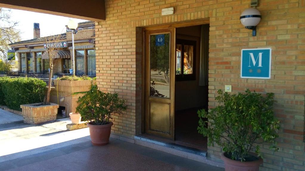 uma entrada para um edifício com uma porta e plantas em Hotel-Motel Sol II em Requena