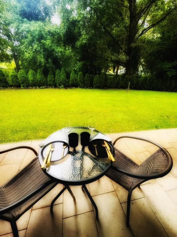 a glass table with glasses on top of a bench at Apartament Solny Resort A032 z klimatyzacją i ogrodem in Kołobrzeg