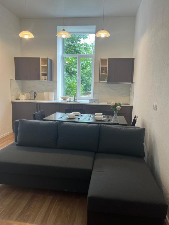 a living room with a couch and a kitchen at Dzīvoklis īstermiņā in Liepāja