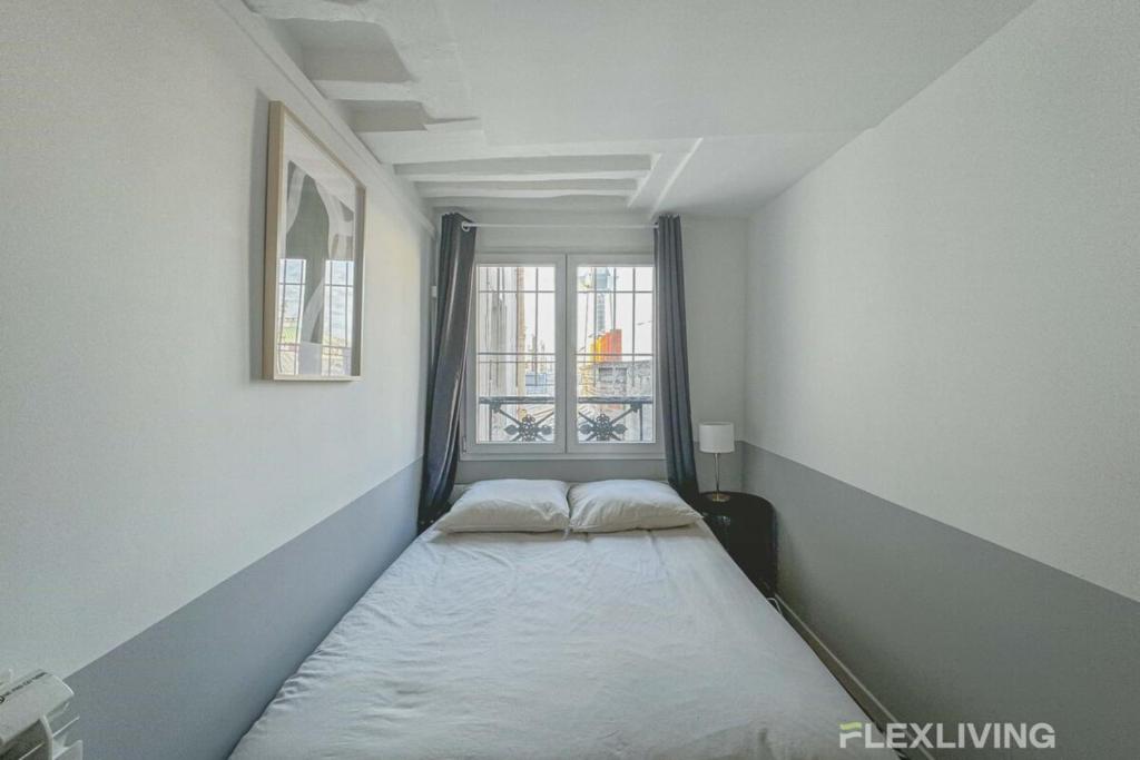 un lit dans une chambre avec une fenêtre dans l'établissement Flexliving - room - Lune, à Paris
