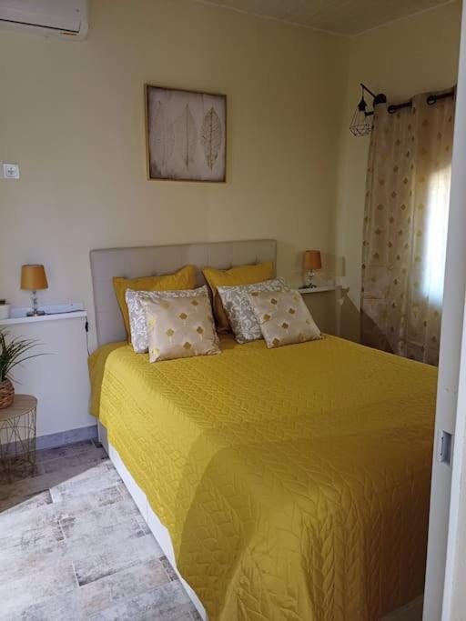 a bedroom with a yellow bed with pillows on it at Casa Vó Elisa com piscina privada in São Bartolomeu de Messines