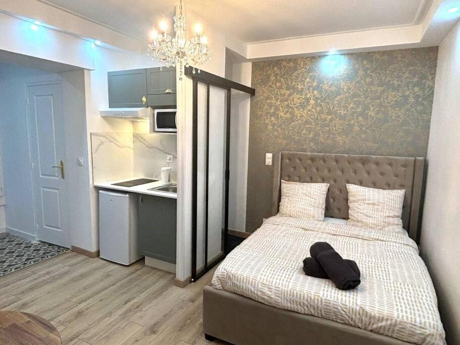 a bedroom with a bed and a chandelier at Le Prince, proche Paris & Disney in Noisy-le-Grand