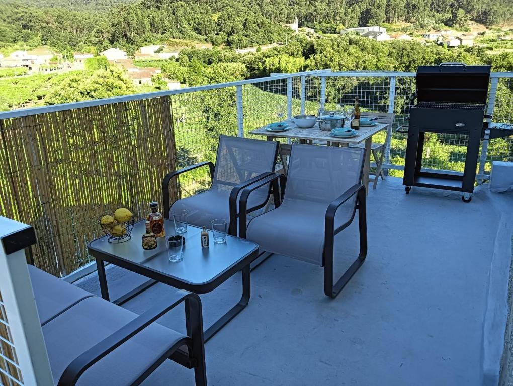 a balcony with a table and chairs and a grill at Casa Duarte, Airiños de Xil in Meaño