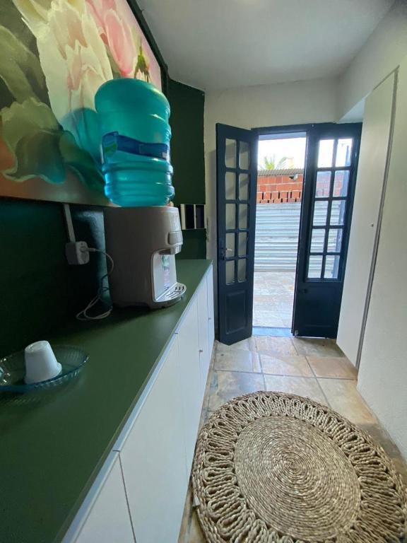 a kitchen with a counter with a door and a rug at Pousada Oásis in Fortaleza