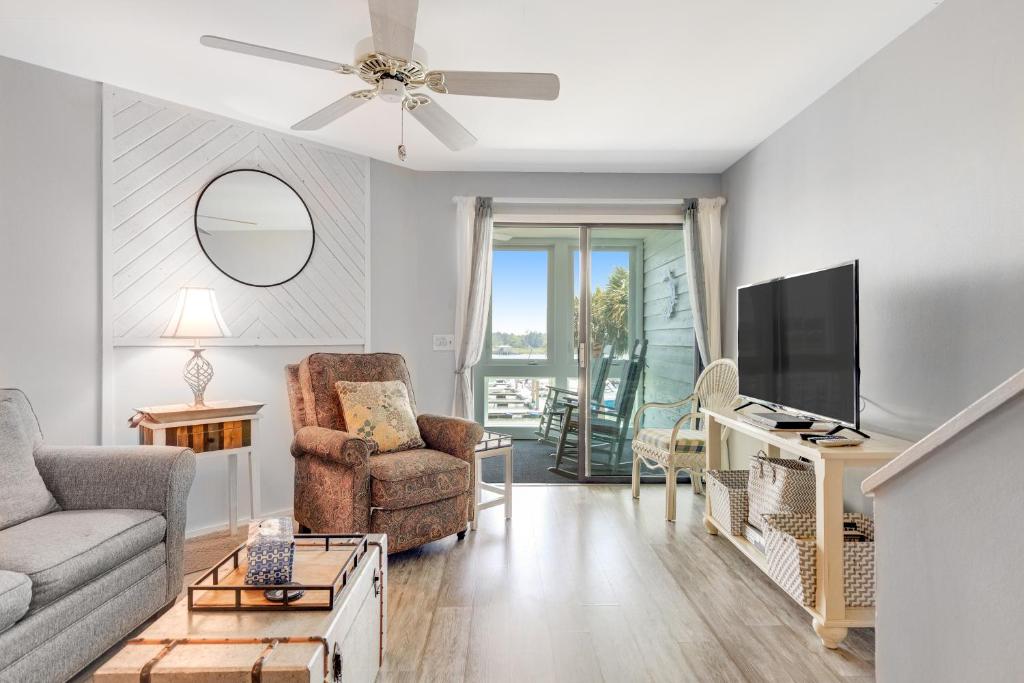 a living room with a couch and a tv at Mariners Cay 74 in Folly Beach